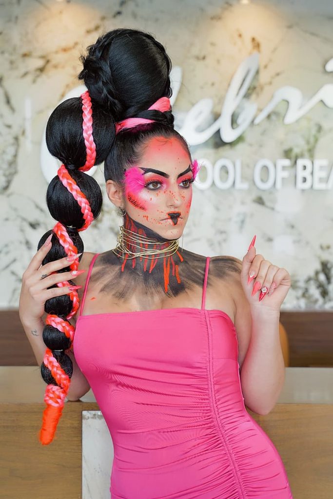 A model with makeup, hair, and nails styled by Celebrity students to resemble a flamingo