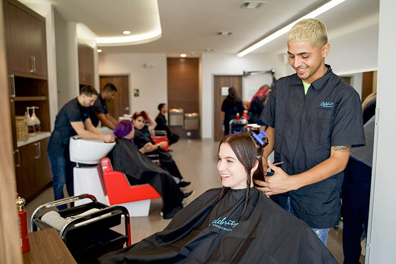 A Celebrity Cosmetology student washing a client's hair in the Celebrity salon.